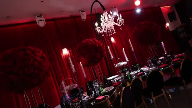 Red floral arrangements and candlelit tables at a birthday celebration in Event Masters Episode 11