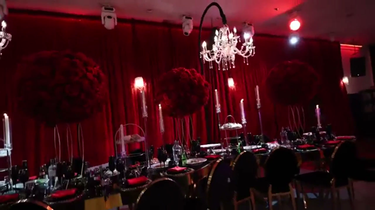 Red florals, chandeliers and candlelight at an R5 celebration